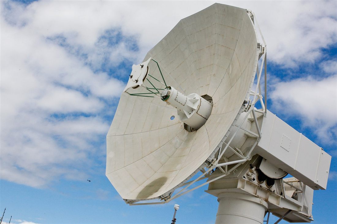 A large radar dish against a blue sky