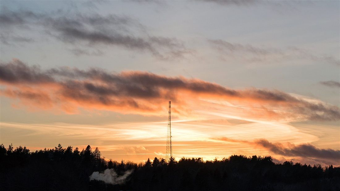 A telecommunications mast silhouetted at sunset